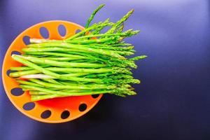 Asparagus - Vegetable. Fresh Asparagus. Pickled Green Asparagus. Bunches of green asparagus in a basket on a dark-black background, top view- Image. photo
