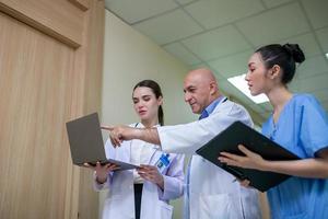 Group of doctors consulting patient records, Elderly doctor and colleague discussing current disease therapy at working place. photo