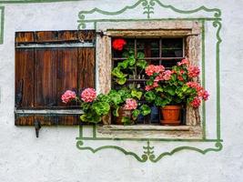 primer plano de una vieja ventana de madera con flores en el alféizar foto