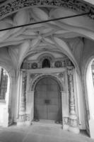 toma en escala de grises de la entrada de una iglesia con un techo ornamental