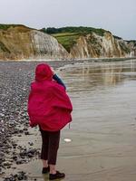 Rear view of the female looking at the high cliffs at Hautot sur Mer in Normandy, France photo