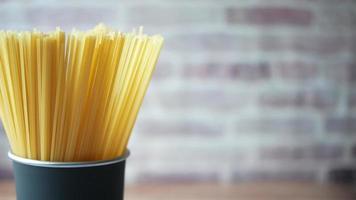 Yellow long spaghetti in a container on table video