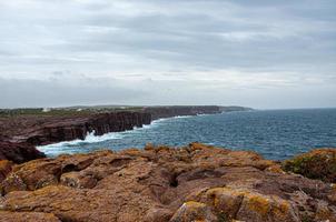 Beautiful view of a sea surrounded by cliffs under a bright sky photo