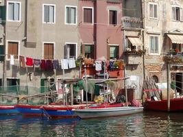 Port of Chioggia with small boats near colorful buildings photo