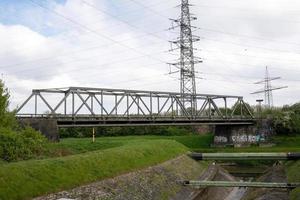 High voltage pylon for power supply with railway bridge