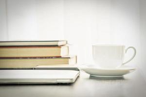 Coffee cup and laptop with book photo