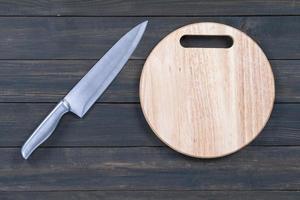 Close up kitchen knife and wooden round cutting board photo