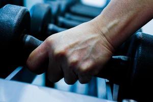 Close up of hand holding dumbbell in fitness. photo