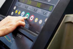 Close up of hand selecting a function from the treadmill. photo