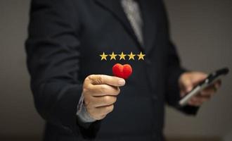 Satisfaction Concept. Customer's highest excellent satifaction the service Five-star rating and a red heart. photo