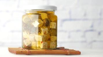 Käsewürfel, Oliven und Kräuter in einem Behälter auf dem Tisch video