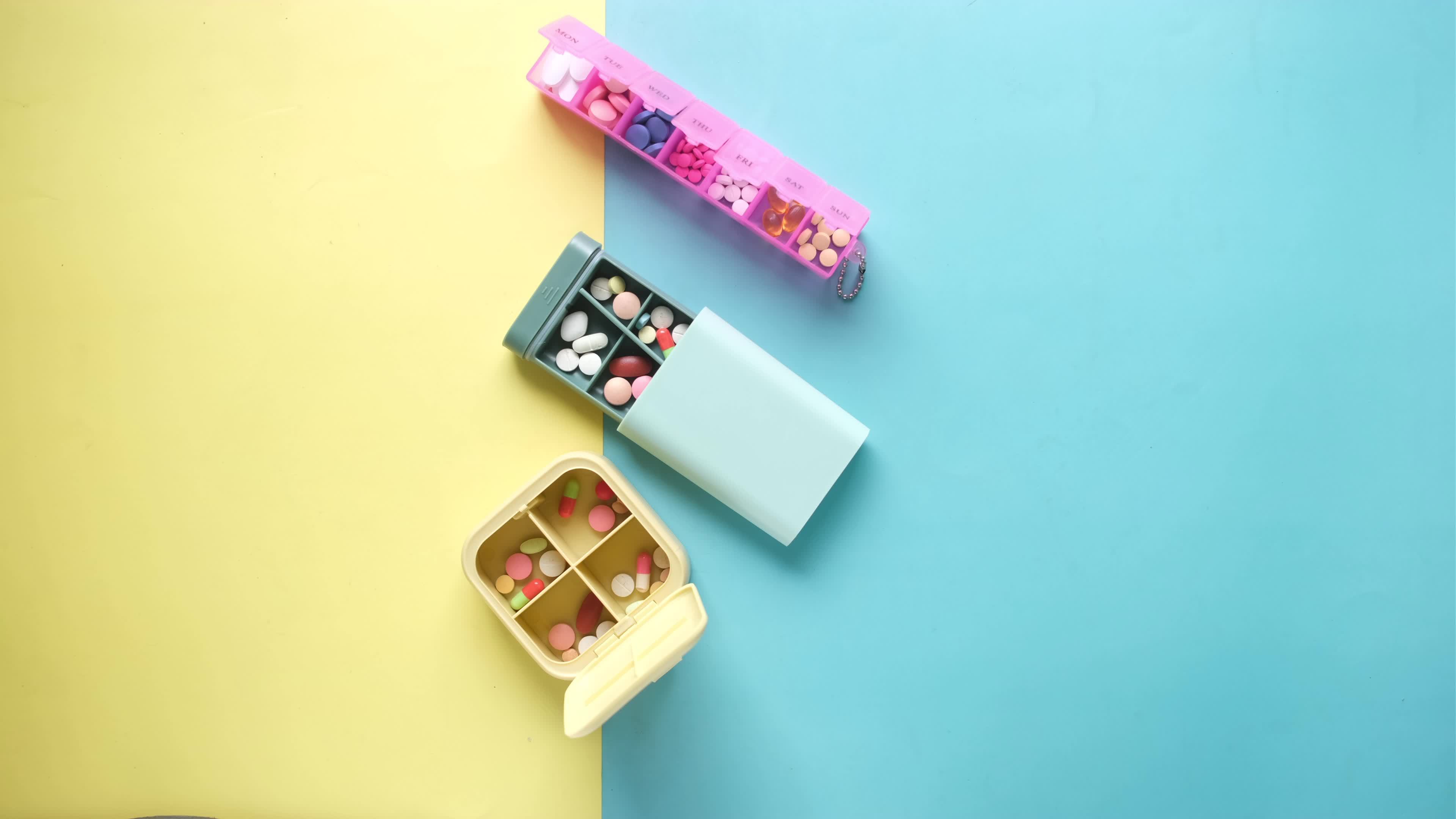 top view of medical pills in a pill box on color background 7263531