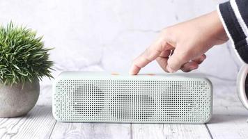 man's hand using smart speaker on table video