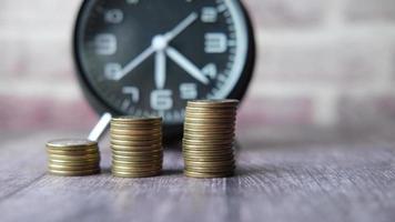 old alarm clock and coins on black background. video