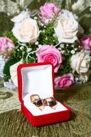 two wedding rings in box and flowers photo