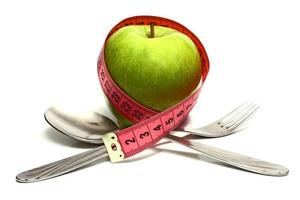 spoon fork and apple is strung by a ribbon for measuring diet photo