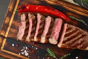 Keto ketogenic diet beef steak, grilled striploin on cutting board. Paleo food recipe with meat photo