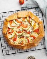 Homemade savory galette with vegetables, wholegrain pie with tomatoes, zucchini, blue cheese photo