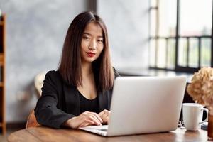 mujer de negocios asiática que trabaja en una computadora portátil en la oficina. empresaria japonesa foto