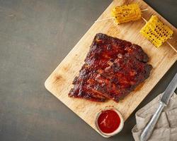 Barbecue pork ribs. Slow cooking recipe. Brown background photo
