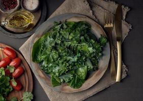 Ensalada de col rizada, hoja de repollo, mezcla verde de lechuga romana en el plato. hojas frescas desnudas. vegano foto