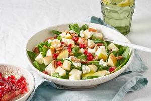 Close up Fruits salad with nuts, balanced food, clean eating. Spinach with apples, pecans and feta photo