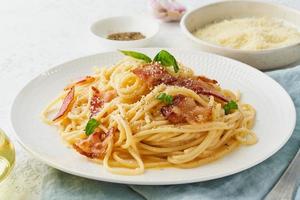 pasta carbonara. espaguetis con panceta, huevo, queso parmesano y salsa de nata foto