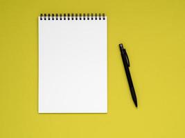 abra el bloc de notas en la espiral con una página blanca limpia y un lápiz en un color de fondo amarillo brillante