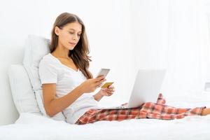 mujer joven comprando en línea, ingresando el código del mensaje sms en el teléfono móvil, seguridad. foto