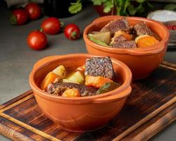 Goulash with large pieces of beef and vegetables. Burgundy meat. Slow stewing photo