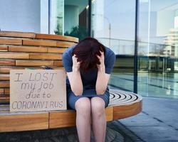 Woman holds sign saying I lost my job because of coronavirus. photo