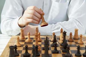 Man play chess during quarantine due to coronavirus pandemic. Boy play Board games. photo