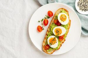 Avocado toast with toasted bread soft-boiled eggs with tomatoes photo