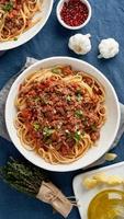 Pasta Bolognese Fettuccine with mincemeat and tomatoes, parmesan cheese. Top view, vertical photo