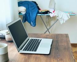 Freelance Desk with laptop in mess at home apartment. Quarantine, self-isolation, sociophobia photo