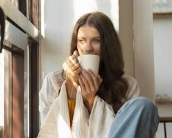 taza de té o café. mujer bebiendo bebidas calientes y disfrutando de la mañana, foto