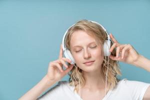 primer plano retrato de mujer joven ojos cerrados escuchando música a través de auriculares
