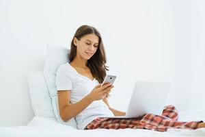 Young woman shopping online, entering code from SMS message on mobile phone, online shopping photo