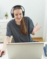 Girl with headphones looks at information on computer with surprise. photo