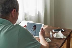 Man looks at tablet, video call to doctor, communication with doctor online. Telemedicine photo