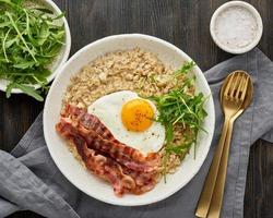 Oatmeal, fried egg and fried bacon. Brutal man sport breakfast. Hearty fat high-calorie breakfast, photo