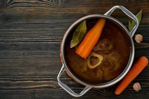 Beef meat broth, ossobuco on bone, rich soup in saucepan, long slow languishing cooking. photo