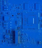 Computer motherboard. Classic blue background with pc backdrop, close up. Single color microchip photo
