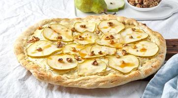 Fruit homemade pear pizza with cheese and honey, Rustic Italian savory food photo