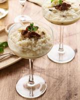 Risotto with mushrooms in wine glass. Unconventional unusual serving. Side view, vertical photo