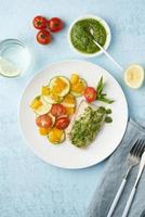 Keto dinner with white fish. Oven baked fillet of cod, pike perch with vegetables and pesto sauce photo