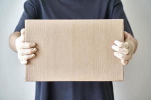 entrega sin contacto de pedidos en línea a la puerta de casa, manos con guantes de goma estériles foto