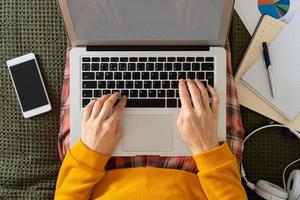 Top view work at home. Distance education. Woman typing to blog on laptop photo