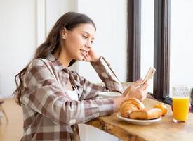Woman looking for information on Internet, smiling and using mobile, photo