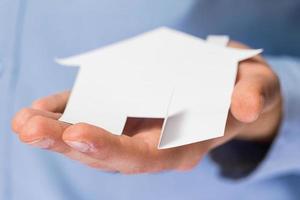 Man holding paper house in his hands photo